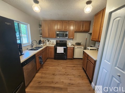 A kitchen with wooden floors and cabinets.