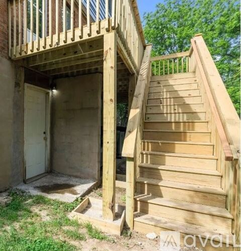 A wooden staircase with a doorway leading to a basement.