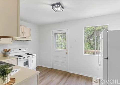 A kitchen with white appliances and wooden cabinets.