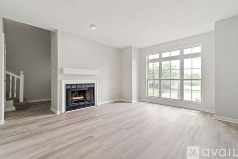 A spacious living room with a fireplace and large windows.