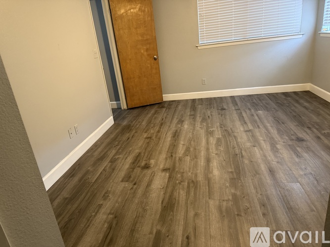 A room with wooden flooring and a door.