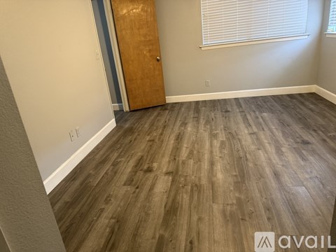 A room with wooden flooring and a door.