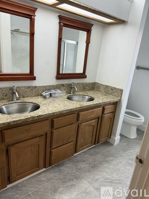 A bathroom with two sinks and a toilet.