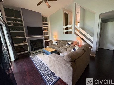A living room with a couch, a fireplace, and a television.