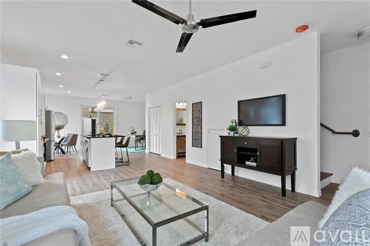 A living room with a white couch and a glass coffee table.