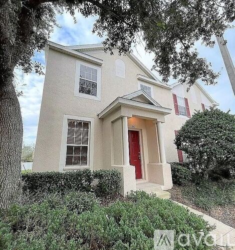 A white house with a red door and windows.