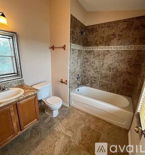 A bathroom with a tub, toilet, and sink.
