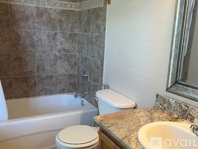 A bathroom with a toilet, sink, and bathtub.