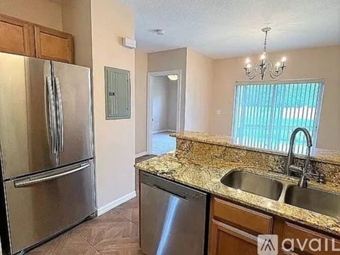 A kitchen with a granite countertop and stainless steel appliances.