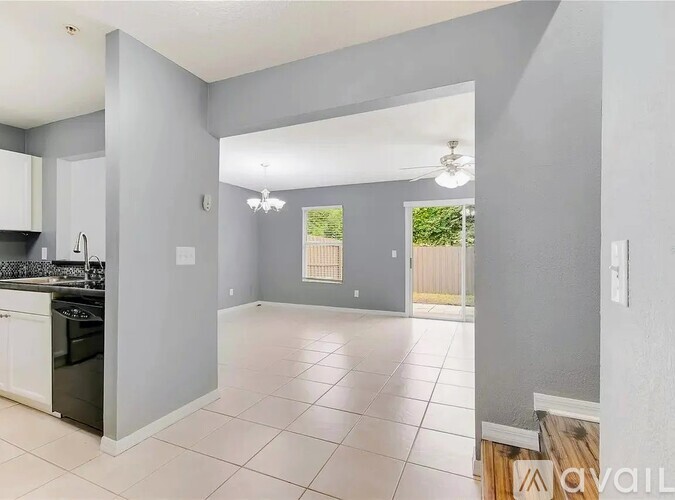 A spacious kitchen with white cabinets and a black stove top oven.
