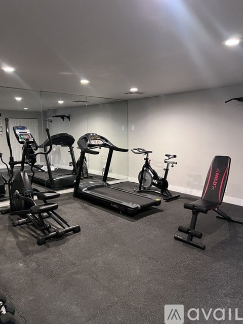 A gym with treadmills, exercise bikes, and weight machines.