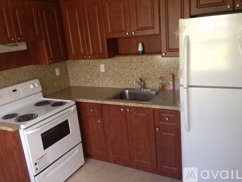A kitchen with white appliances and brown cabinets.