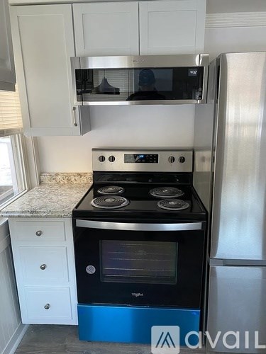 A kitchen with a blue stove and white cabinets.