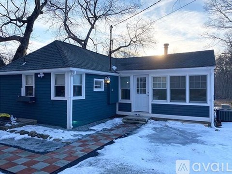 A blue house with a white door and windows is shown in the image.