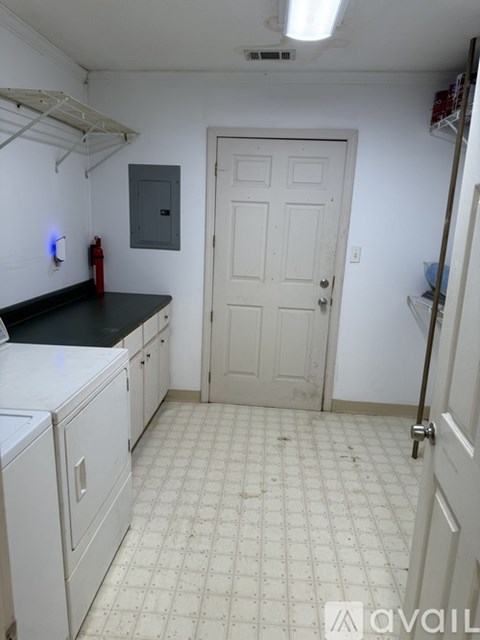 A kitchen with white cabinets and a black counter top.