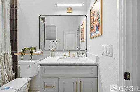 A bathroom with a white toilet, sink, and mirror.