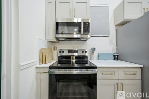 A kitchen with white cabinets and a black stove top oven.
