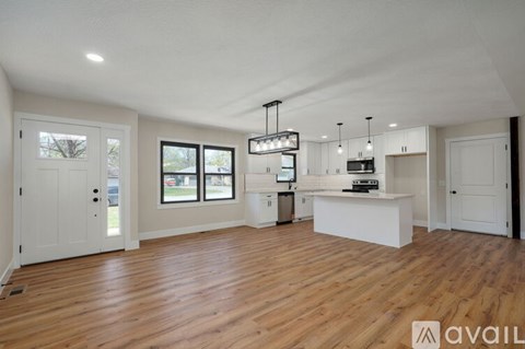 A spacious room with wooden floors and white walls.