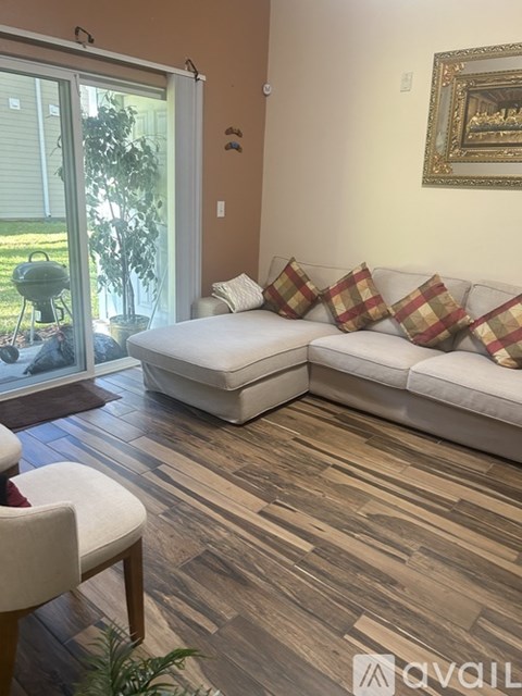 A living room with a white couch and a painting on the wall.