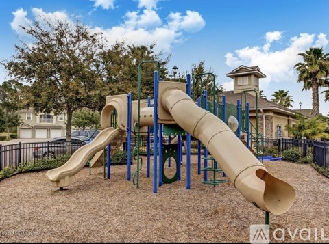 A playground with a slide and a green and blue structure.