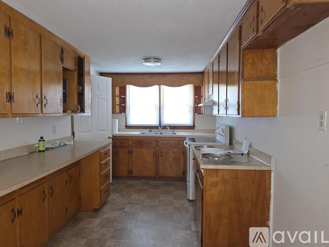 A kitchen with wooden cabinets and a tiled floor.