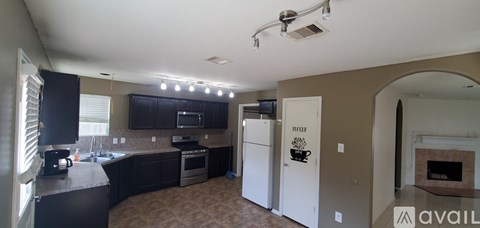 A kitchen with a black counter top and white appliances.