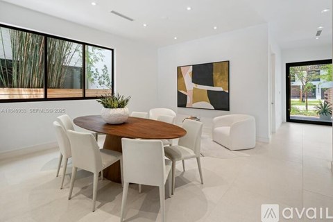 A modern dining room with a wooden table and white chairs.