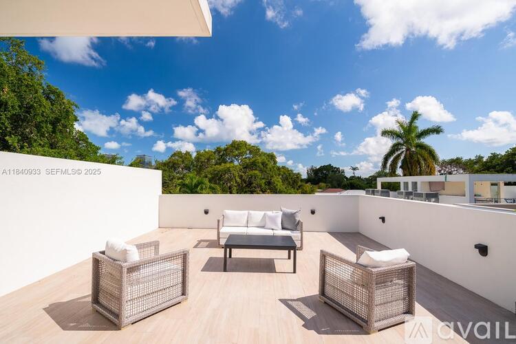 A sunny day on a patio with white furniture.