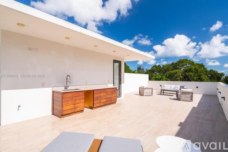 A modern house with a wooden kitchen island and a patio area.