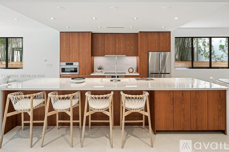 A modern kitchen with wooden cabinets and white countertops.