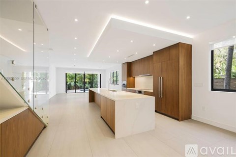 A modern kitchen with wooden cabinets and a white island.