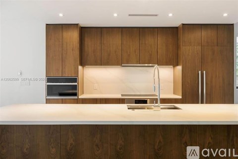 A modern kitchen with wooden cabinets and a white countertop.