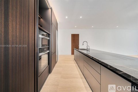 A modern kitchen with dark wood cabinets and a white countertop.