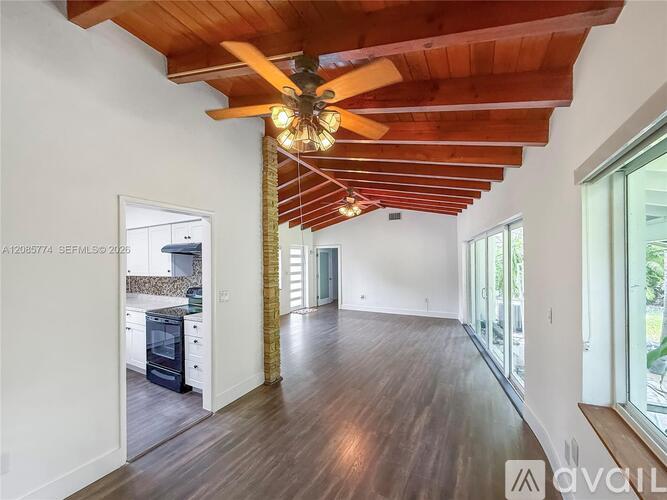 A modern open-concept living space with a wooden ceiling and floor.