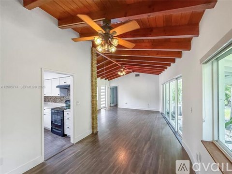 A modern open-concept living space with a wooden ceiling and floor.