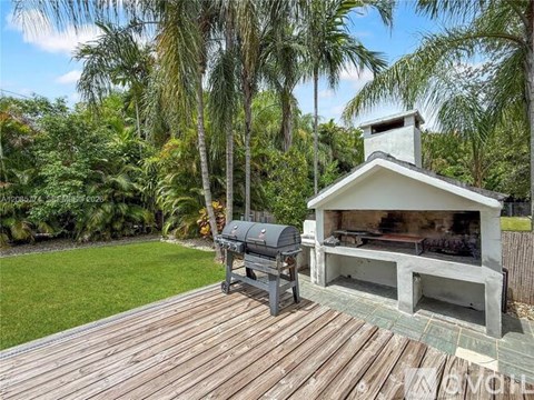 A wooden deck with a grill and a built-in BBQ area.