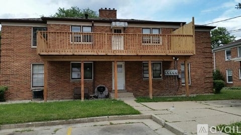 A brick building with a wooden balcony on the second floor.