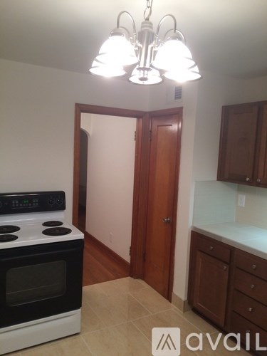 A kitchen with a stove top oven and a chandelier.