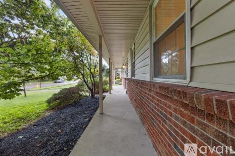 A house with a brick wall and a gravel path.