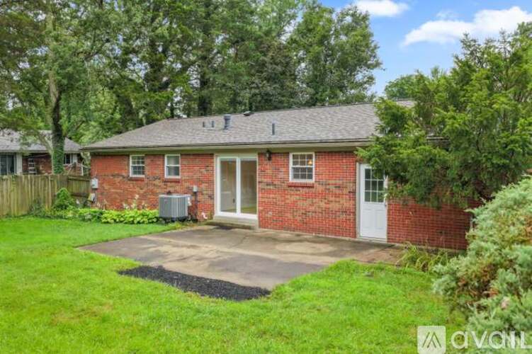 A red brick house with a white door and a small porch.