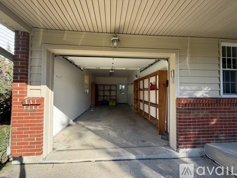 A garage door is open, revealing a carpeted garage interior.