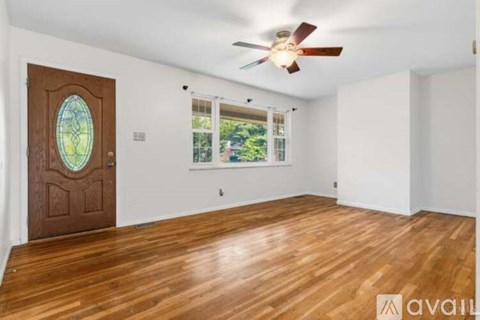 A room with a wooden floor and a ceiling fan.