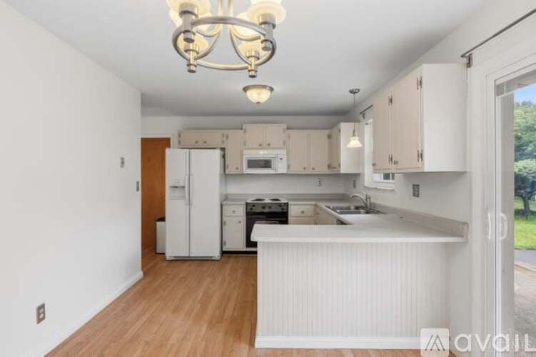 A kitchen with white cabinets and a wooden floor.