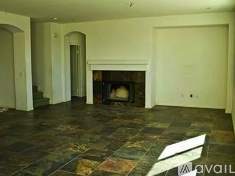 A living room with a fireplace and a stone floor.