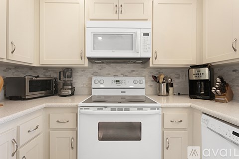 A kitchen with a white stove top oven and a microwave above it.