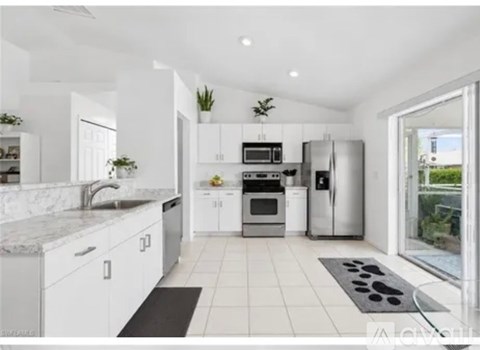 A modern kitchen with white cabinets and stainless steel appliances.