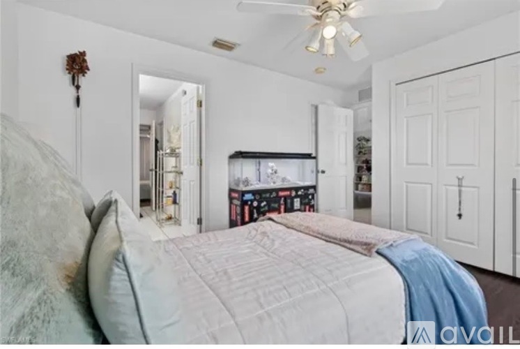A bedroom with a large bed and a ceiling fan.
