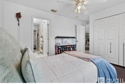 A bedroom with a large bed and a ceiling fan.