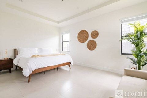 A bedroom with a white bed and a bench.