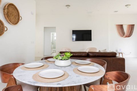 A modern dining room with a round table set for four.